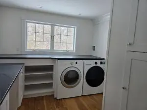 Interior painting in a Sunapee NH laundry room with crisp white walls and cabinets