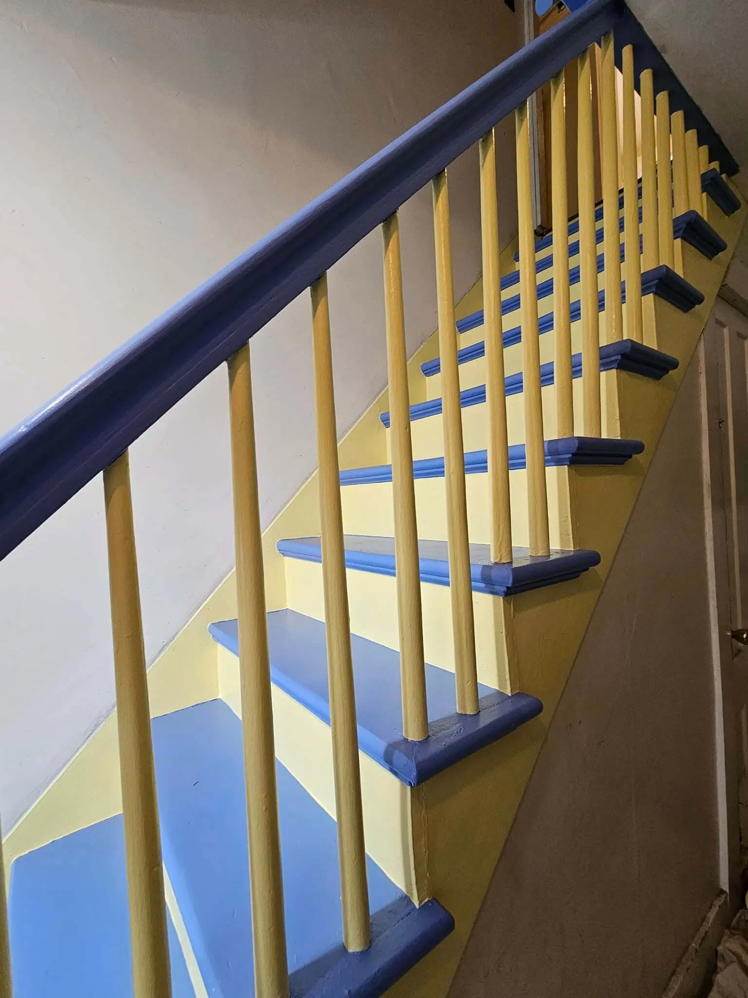 Interior painting with a bold yellow and blue color combination on a NH staircase