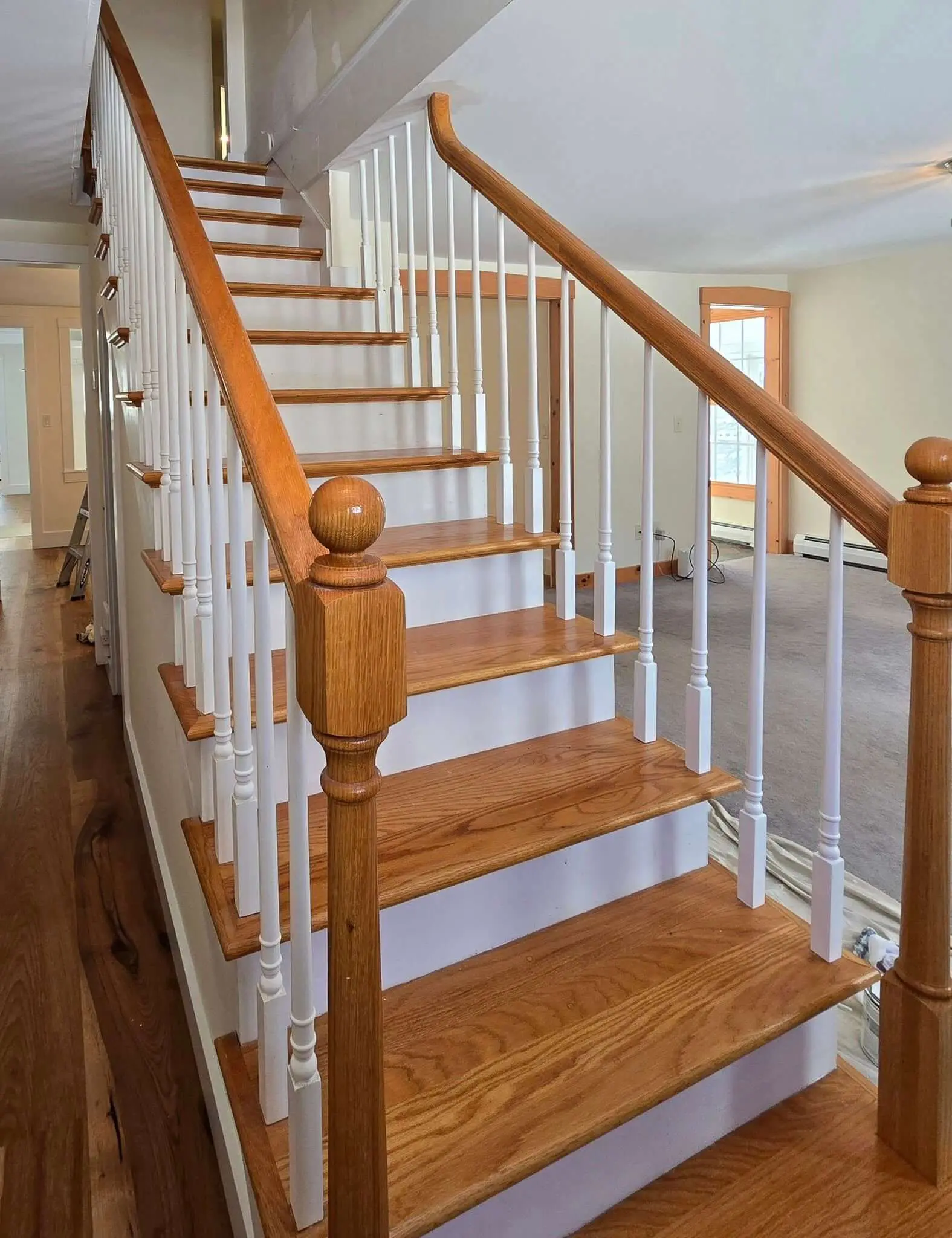 Staircase repaint in progress with freshly painted white spindles and stained treads