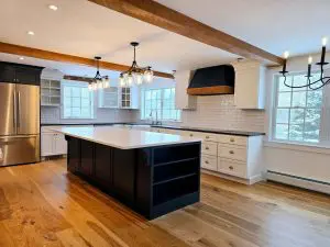 Cabinet painting in Sunapee NH kitchen with black island and white perimeter cabinets