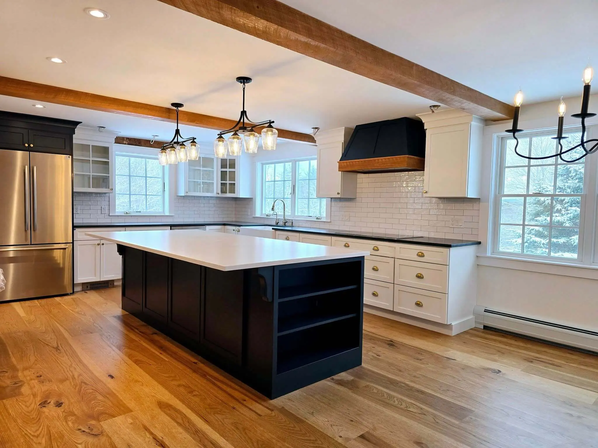 Cabinet painting in Sunapee NH kitchen with black island and white perimeter cabinets